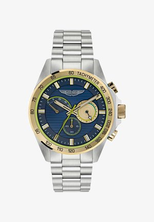 RVS horloge met een blauwe gestructureerde wijzerplaat, gouden en groene accenten, tachymeterschaal en drie subdialen op een metalen armband.