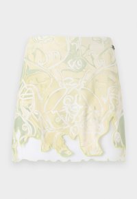 Kort skjørt med et bølgende design, med et lett gult og grønt svirvelmønster og en bølget kant som er omkranset av lysegul.