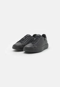 Czarne skórzane sneakersy o teksturowanym wykończeniu, z płaskimi sznurowadłami, okrągłym czubkiem i gładką gumową podeszwą. Prosty, minimalistyczny design.