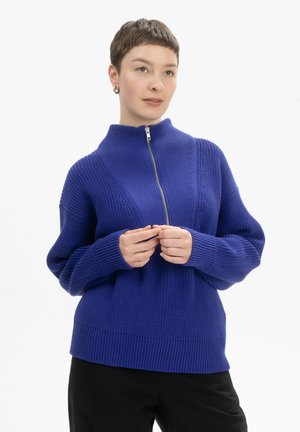 Paars gebreid sweater met een hoge kraag en een asymmetrische rits. Bevat geribbelde manchetten en zoom, en heeft textuurpatronen door het geheel. Comfortabele pasvorm.