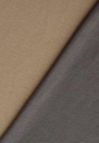 Μπεζ και γκρι υφασμάτινα κομμάτια με υφή που επικαλύπτονται διαγώνια, δείχνοντας λεπτά υφαντά σχέδια και απαλό υλικό.