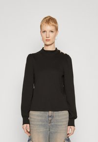 Black long-sleeve top with a high collar, featuring puffed shoulders and gold button accents on one shoulder. Soft, stretchy fabric.
