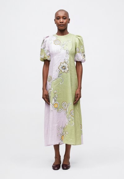 Robe mi-longue vert clair et lavande avec des manches bouffantes, broderies florales en jaune et blanc, tissu texturé et coupe droite simple.
