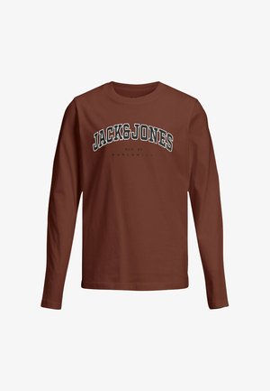 T-shirt rouge à manches longues avec "JACK & JONES" imprimé en noir sur la poitrine, associé à un jean gris ample et des chaussures de sport blanches.