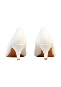 Paire de chaussures blanches en cuir à talon kitten vues de dos sur un fond blanc.