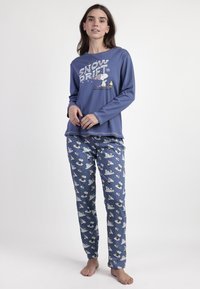 Camisa de pijama azul de manga larga con gráfico de "SNOW DRIFT", combinada con pantalones azules a rayas que presentan osos polares y estrellas.