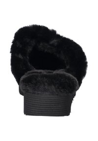 Zwarte fuzzy slipper met een ronde open achterkant, pluche voering en een geribbelde zool voor grip. Zacht, gestructureerd nepbontmateriaal overal.