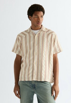 Camisa de manga corta en una tela color beige claro con rayas verticales en crema y granate. Cuenta con cuello puntiagudo y cierre de botones.