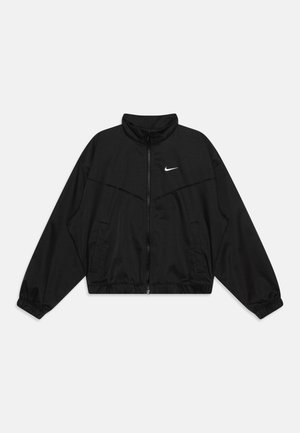 Czarna kurtka Nike zapinana na zamek z wysokim kołnierzem, elastycznymi mankietami, bocznymi kieszeniami oraz białym logo Nike Swoosh na lewej piersi.