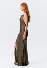 Olive green satin dress with a straight neckline, side slit, and streamlined silhouette. Features minimal seams and sleeveless design.