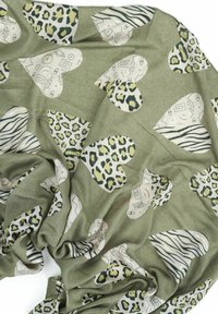 Tessuto verde oliva con grandi cuori bianchi caratterizzati da motivi astratti, a zebra e a leopardo sparsi sulla superficie.