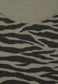 Schwarz- und graustripes Stoff mit einem Wellenmuster, ausgestattet mit einem runden Halsausschnitt und sichtbaren Nähten entlang der Ränder.