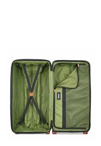 Valigia rigida con interno verde caratterizzato da un motivo a onde, cinghie di compressione, una tasca in rete con zip e dettagli della cerniera arancioni.