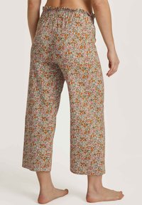 Bloemmotief broekjes met een elastische tailleband, featuring roze, oranje en groene tinten op een neutrale achtergrond.