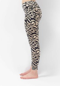 Leggings met een beige en zwarte tijgerstripenpatroon, gemaakt van rekbare stof met een hoge tailleband en platte naden voor extra comfort.