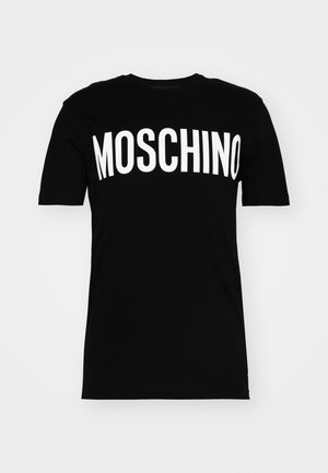 T-shirt de algodão preto com mangas curtas, apresentando um destacado logótipo branco "MOSCHINO" atravessando o peito em letras maiúsculas e negrito.