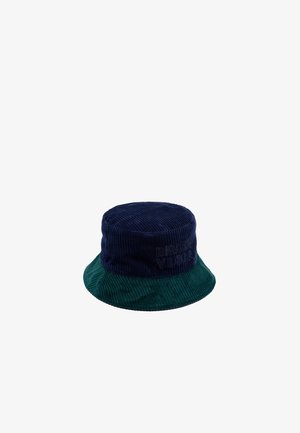 Chapeau seau en velours côtelé, avec un dessus bleu marine et un bord vert. Lettrage brodé visible sur le tissu bleu marine. Surface texturée.