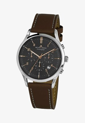 Silberner Chronograph mit einem dunklen Zifferblatt, braunem Lederarmband, silbernen Akzenten und einer Datumsanzeige. Verfügt über markante Stundenmarkierungen und Zeiger.