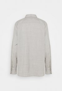 Langärmliges, hellgraues Hemd mit einer sanften Textur, einem Button-Down-Kragen und hochrollbaren Knopfdetails an den Ärmeln.