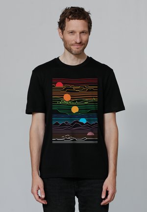 Zwarte katoenen t-shirt met een kleurrafische afbeelding van zonnen, lijnen en bergen in levendige kleuren, gepresenteerd op een rechthoekig ontwerp.