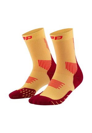 Yellow and red athletic socks featuring a textured design, with a ribbed upper, padded heel, and patterned accents on the footbed.