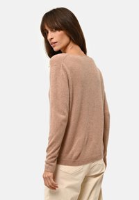 Hellbrauner Cashmere-Pullover mit lockerer Passform, langen Ärmeln und subtiler Textur, von hinten vor einem schlichten Hintergrund gezeigt.