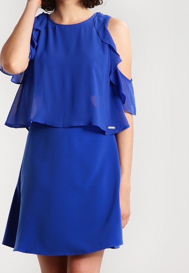 Vestido azul con superposición de volantes en capas y diseño de hombros fríos. Hecho de una tela liviana, presenta un escote redondo clásico y falda acampanada.