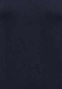 Gros plan sur un tissu bleu marine avec une texture de tricot fine et lisse et un subtil côtelé.