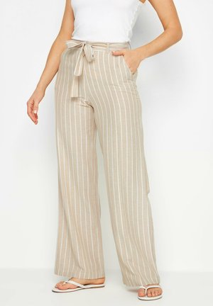 Pantalons larges rayés beiges avec une taille à nouer, fabriqués dans un tissu doux. Comprend des poches latérales et des rayures verticales blanches.