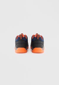 Sorte og orange sportsko med en struktureret mesh-overdel, fremtrædende orange detaljer og polstrede såler for støtte.