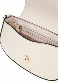 Sac en cuir beige clair avec un rabat arrondi, une fermeture magnétique et une poche zippée intérieure. Texture lisse et bords noirs contrastés.