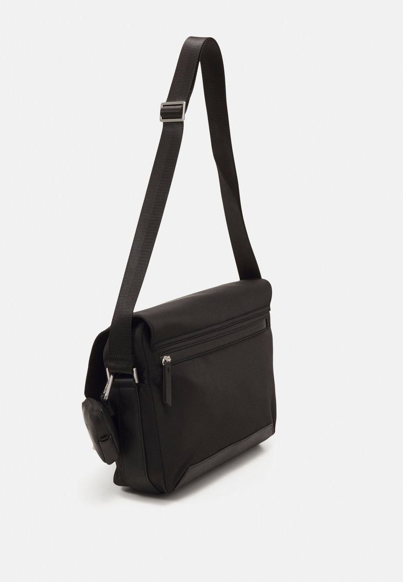 Borsa a tracolla nera caratterizzata da un tessuto morbido e resistente all'acqua, forma rettangolare, tracolla regolabile e tasca frontale con zip.