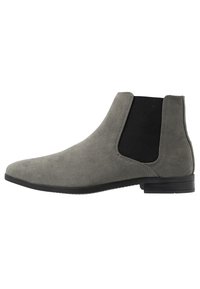 Botas chelsea cinzentas em camurça com painéis elásticos laterais pretos, bico arredondado, sola de borracha plana e costura mínima. Textura suave.