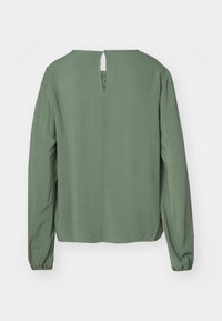 Grønn langermet bluse med rund hals og nøkkelhull bakdetalj, laget av mykt stoff med en jevn tekstur.