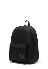 Zaino Herschel nero con tasca frontale con zip, maniglia superiore e spallacci imbottiti su sfondo bianco.