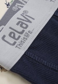 Marinfärgad stickad tyg med en grå elastisk midjeband, som har det präglade logotypen "CeLaVi" och texten "Detta är livet..." på midjebandet.