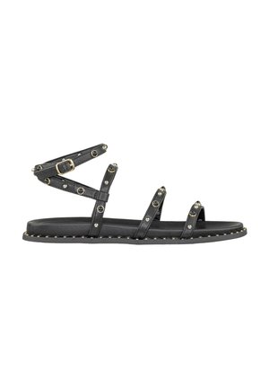 Sandali in pelle nera con molteplici cinturini alla caviglia, decorati con borchie circolari, e una suola piatta con cuciture decorative lungo il bordo.