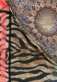 Wielokolorowe tkaniny z kwiatowym wzorem, kratkowanym designem i motywem zebry; materiały wyglądają na miękkie i tkane.