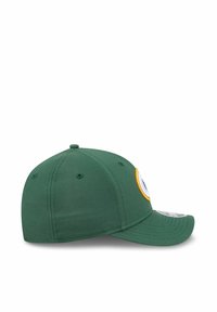 Casquette de baseball verte avec une visière plate, arborant un grand logo rond entouré de jaune à l'avant, et des trous de ventilation sur les côtés.