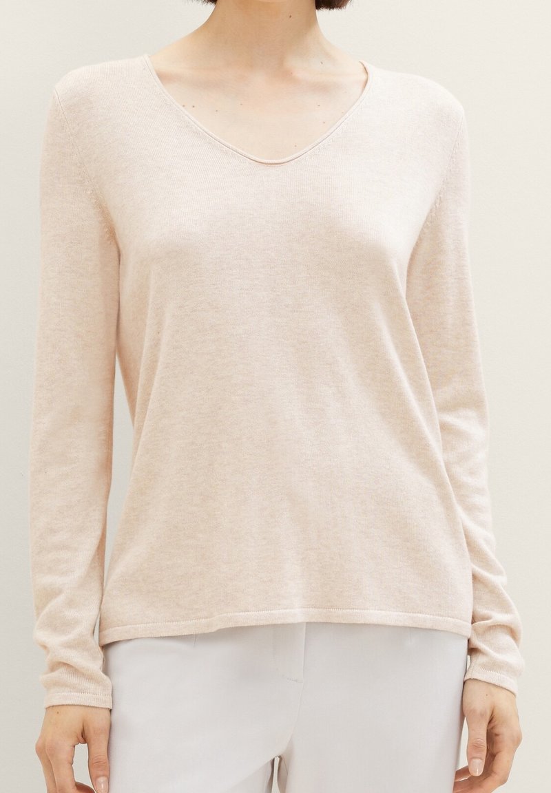 Hellrosa, langärmliger Pullover mit V-Ausschnitt, weichem Textil und entspannter Passform. Mit gerippten Bündchen und einem fertig gearbeiteten Saum.