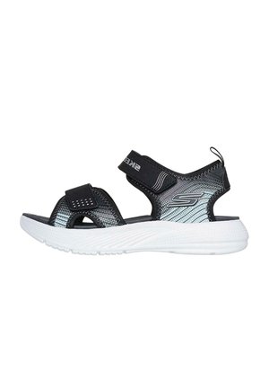 Sandalias deportivas negras y plateadas con correas de Velcro, diseño de punta abierta y suelas texturizadas. Suela de goma blanca, materiales ligeros y transpirables.