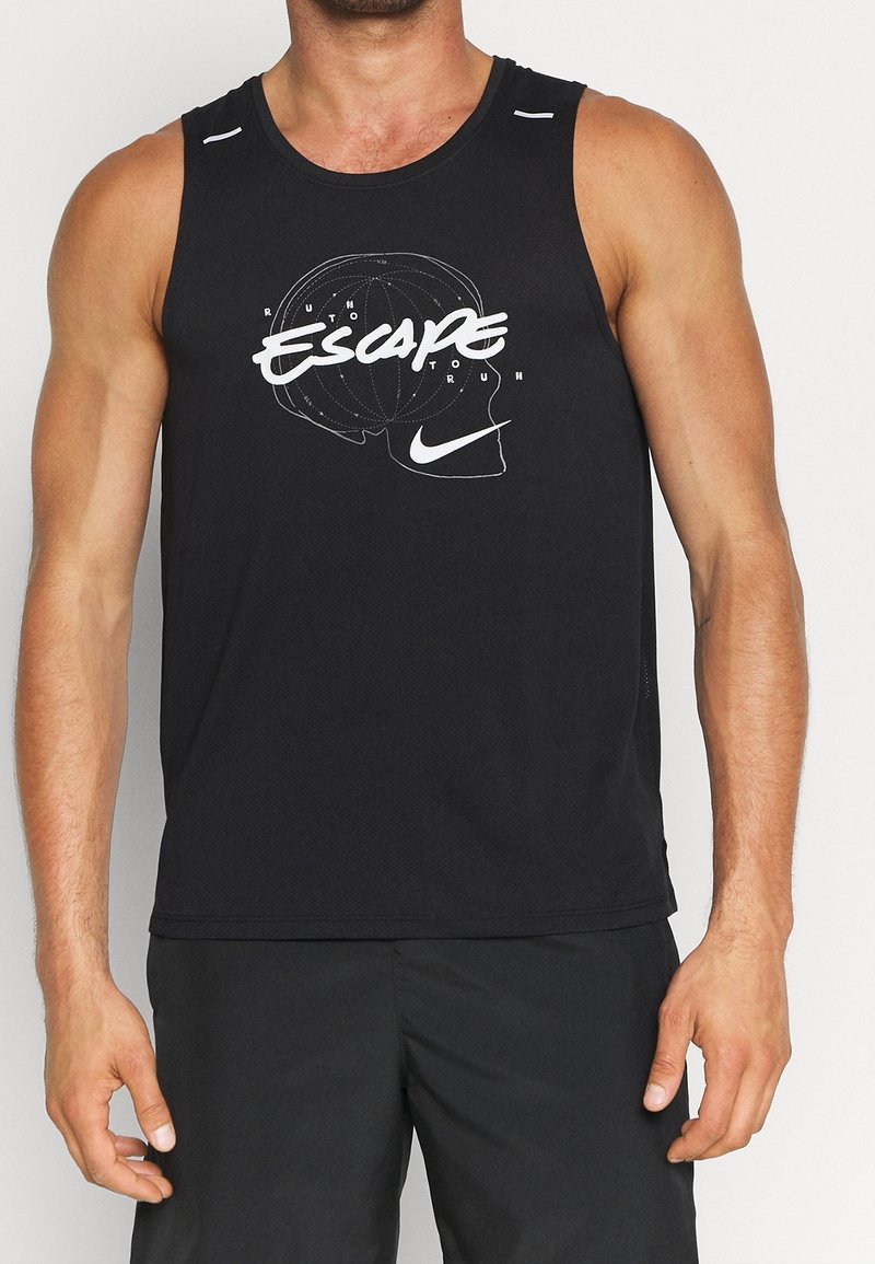 Homme portant un débardeur de sport noir avec un texte graphique blanc « Escape » sur un contour de cerveau et le logo Nike, associé à un short noir.
