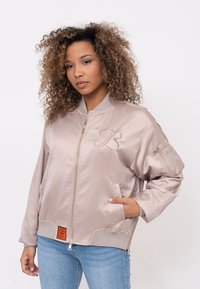 Bomber jacket rosa chiaro in satin con zip dorata, tasche laterali, logo ricamato e polsini e orlo a costine.