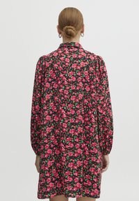 Abito nero con un vivace motivo floreale rosa. Presenta maniche a sbuffo e una vita arricciata, con una silhouette A-line fluida.