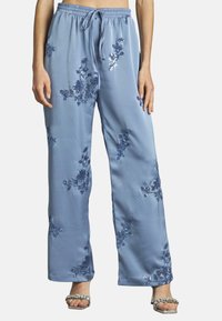  Lichtblauwe satijnen broek met een elastische tailleband, versierd met blauwe bloemenborduursels en pailletten, met een losse, rechte pasvorm.