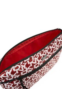 Bolsa de tela con un diseño a rayas rojas y blancas, que cuenta con un cierre de cremallera y un interior rojo suave. Incluye una pequeña placa metálica de marca en la parte frontal.