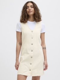 Kremfarget denimkjole med V-hals, frontknapper og sidelommer. Har et formet liv og utsvingt skjørt.