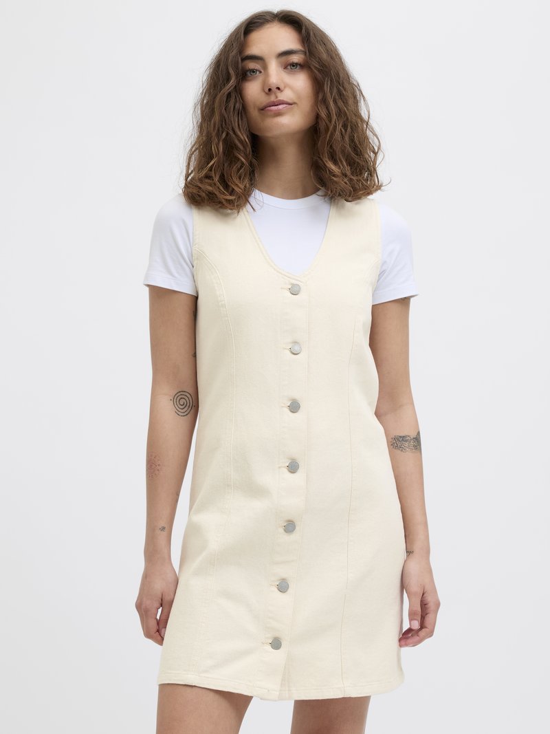 Kremfarget denimkjole med V-hals, frontknapper og sidelommer. Har et formet liv og utsvingt skjørt.