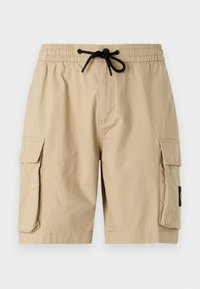 Beige Cargo-Shorts mit einem elastischen Bund und schwarzem Kordelzug, seitlichen Taschen und einer lässigen Passform. Der Stoff wirkt leicht.