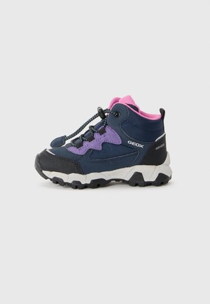 Bota de senderismo para niños en azul marino y púrpura con forro interior rosa, suela en blanco y negro, cordones elásticos y marca Geox en el lateral.